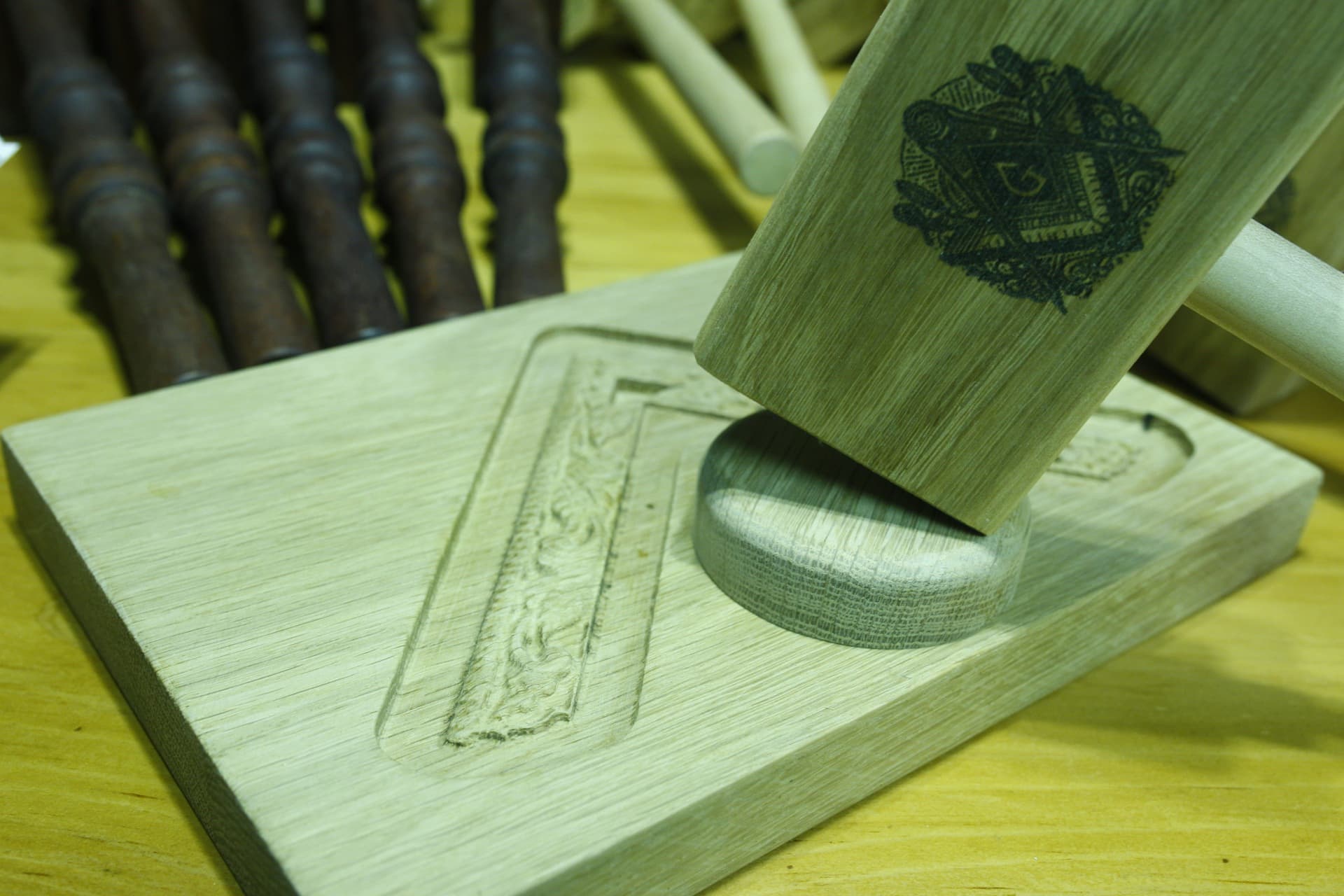 Macro detail of custom hand-carved oak block with engraved emblem